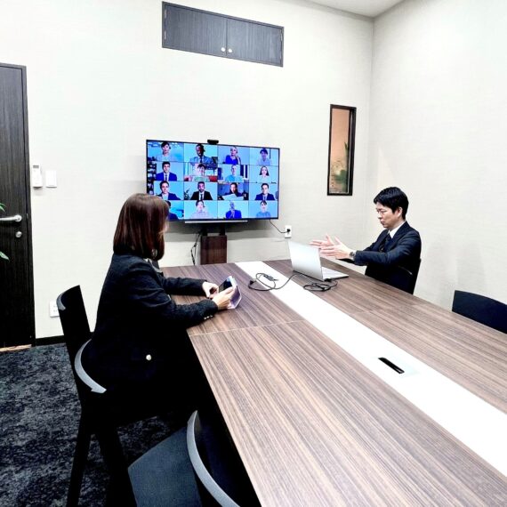 海浜幕張・WBGのオフィスサービスUSP｜8名用大会議室でオンラインミーティングを行う様子｜大型モニター完備のレンタル会議室